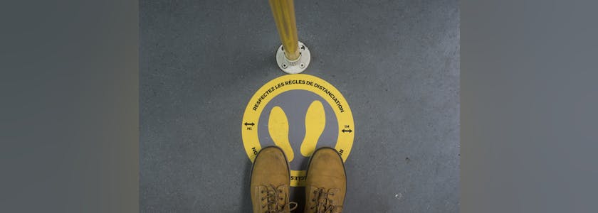 Closeup of social distancing symbol on the floor in the tramway during the Covid-19 pandemic with text in french respectez la distanciation, traductiion in english : respect the distancing.