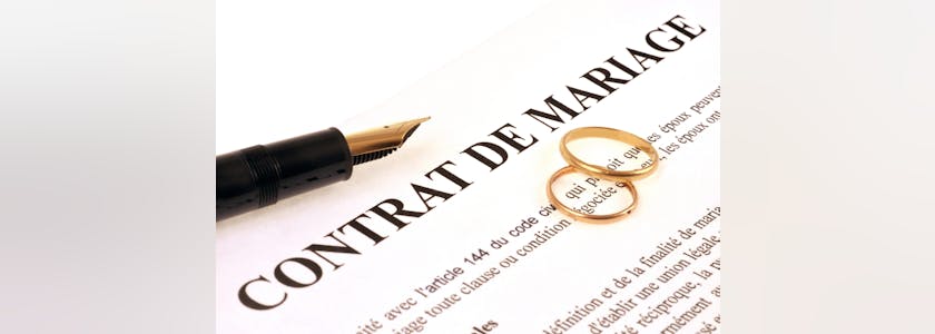 Alliances et stylo plume sur un contrat de mariage