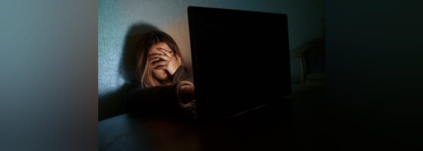 Teenager girl suffering internet cyber bullying scared and depressed cyberbullying. Image of despair girl humilated on internet by classmate. Young teenage girl crying in front of the laptop