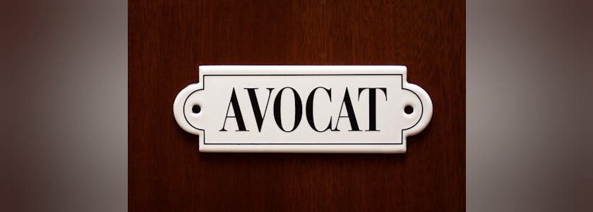 A closeup on door with lawyer name Avocat in french. Concept of lawyer services.
