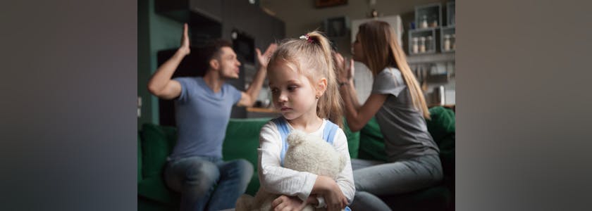 Kid daughter feeling upset while parents fighting at background