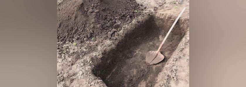 Digging a pit. Pit in the ground. The shovel in the pit.