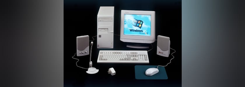 Nineties obsolete tower pc computer and Windows 95 logo on scree