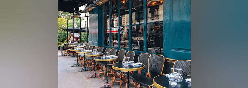 Tables and chairs in outdoor cafe in Paris, France.