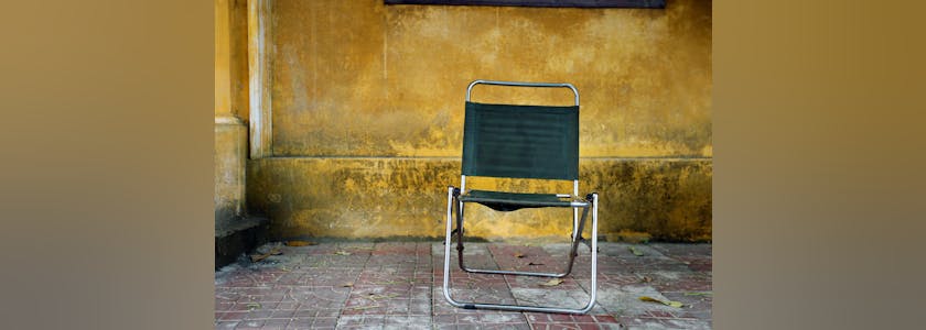 Vintage fabric chair placed in front of yellow wall, Vietnam, Hoi An