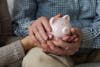 Saving money investment for future. Senior adult mature couple hands holding piggy bank with money coin. Old man woman counting saving money planning retirement budget. Investment banking concept.