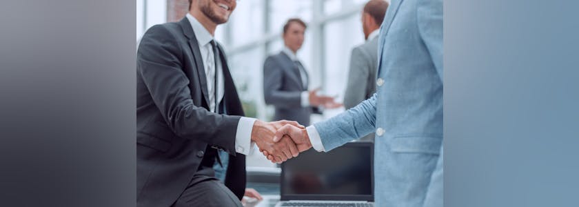 happy young businessman shaking hands with his business partner