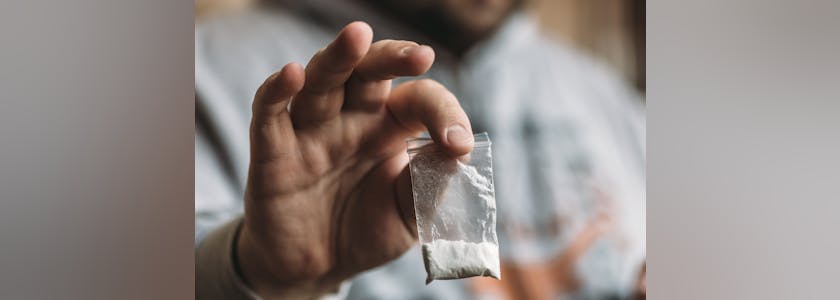 1679762 Man hand holding cocaine or other drugs, drug abuse