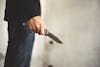 Close up of man holding knife in abandoned house. Terrorist and Robber concept. Police and Soldier. Weapon and armed theme